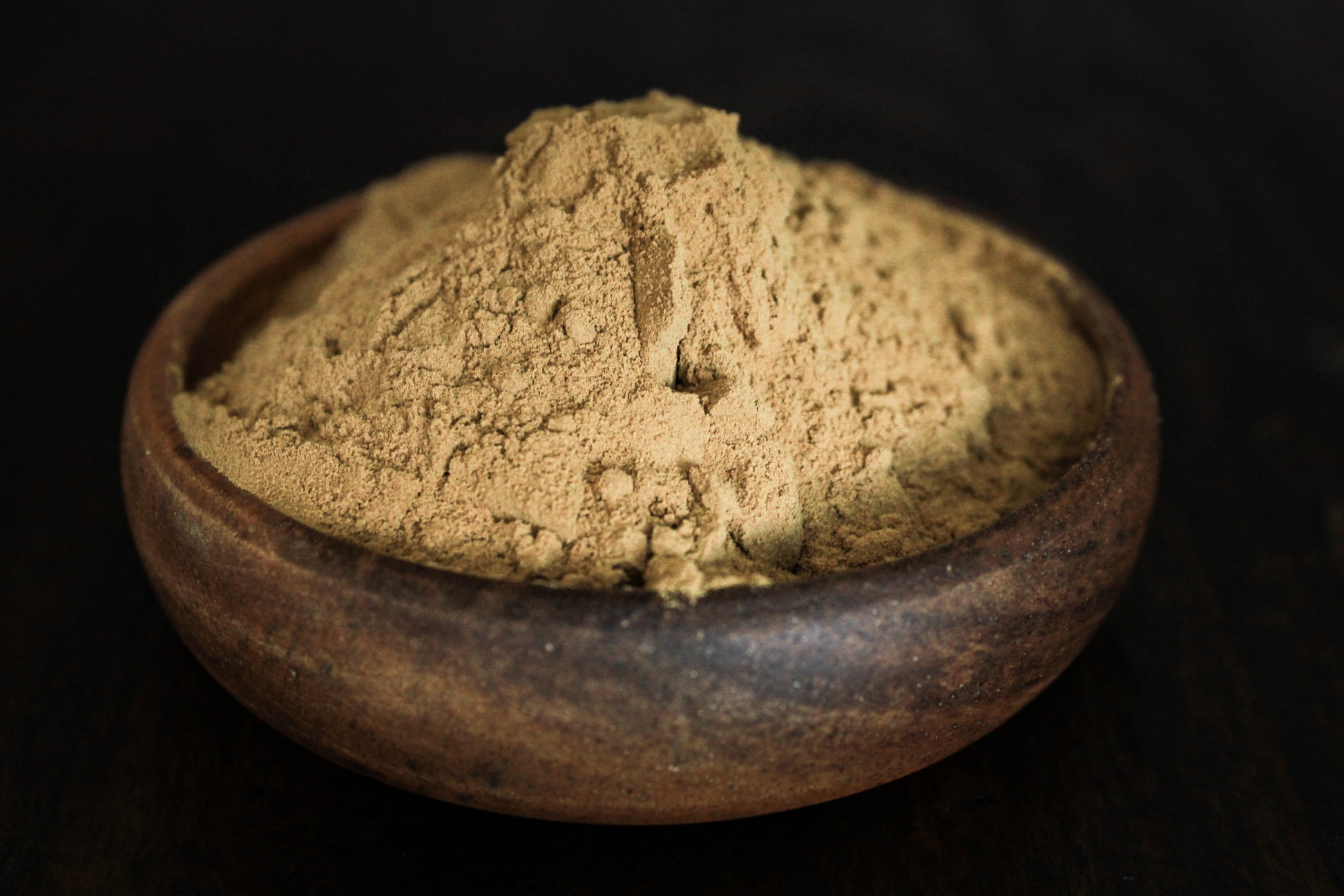Fresh fine blue lotus powder shown in wooden bowl